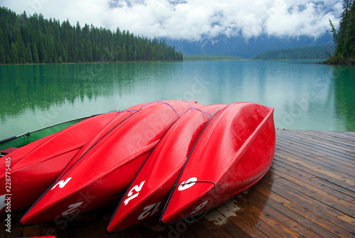 Foto Colorful Red Canoes Lined up On Dock by Mountain Lake