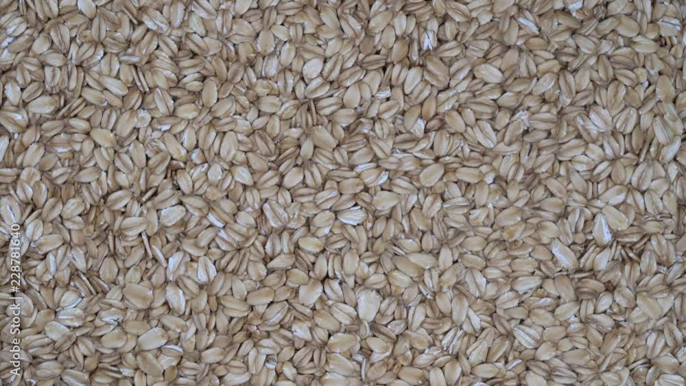 Dry oat flakes grains background, close up rotation loopable 4k top view. Food background. Gastronomy concept, organic food. Macro rotation oat flakes Dry oat flakes grains background, close up rotation loopable 4k top view. Food background. Gastronomy concept, organic food. Macro rotation oat flakes