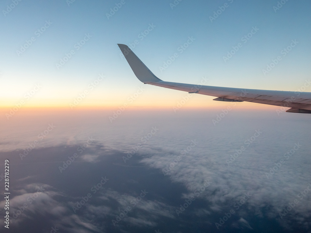 Looking outside Comertial Airplane at Sunrise with White Clouds in the horizon Looking outside Comertial Airplane at Sunrise with White Clouds in the horizon