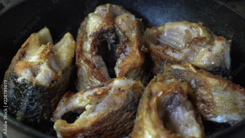 Fish fried in a frying pan until golden brown. Pieces of fresh fish are fried in a frying pan in flour. Chef is cooking fish. Fried piece of carp. Close up Fish fried in a frying pan until golden brown. Pieces of fresh fish are fried in a frying pan in flour. Chef is cooking fish. Fried piece of carp. Close up