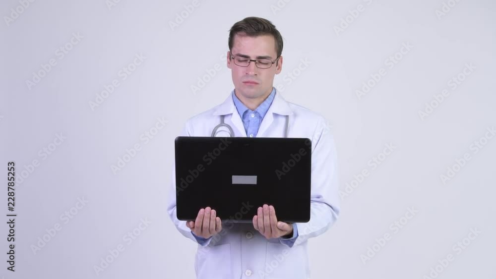 Young happy handsome man doctor using laptop Young happy handsome man doctor using laptop