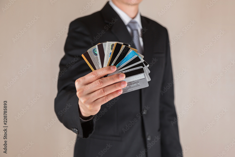 BANGKOK, THAILAND OCTOBER - 14 2017: Close up of businessman holding the many credit and debit card before buying product. BANGKOK, THAILAND OCTOBER - 14 2017: Close up of businessman holding the many credit and debit card before buying product.