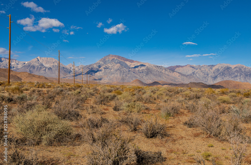 Fototapeta premium Black Mountain with open field and power lines running to the mountains
