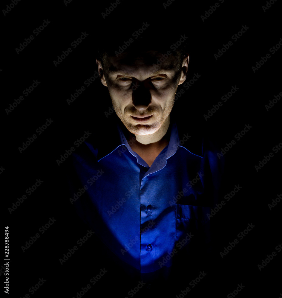 Stylish dark portrait of adult caucasian man who seems like maniac or psycho. Isolated on black background. Low-key lighting. Stylish dark portrait of adult caucasian man who seems like maniac or psycho. Isolated on black background. Low-key lighting.