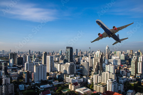 Airplane flying on cityscape as travel and transportation concept