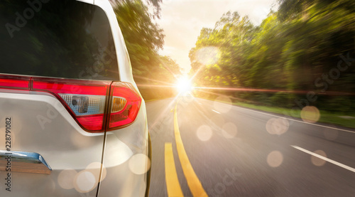 Close up back of car is running on asphalt road in summer