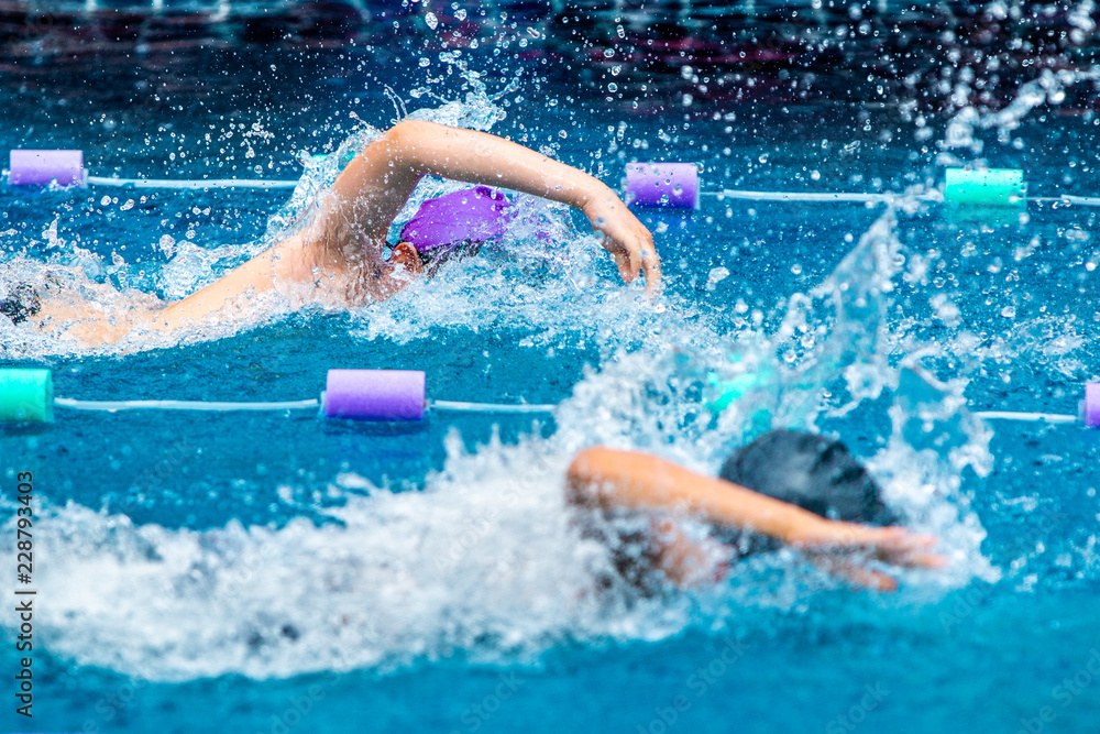 Young boy swimmers racing in freestyle