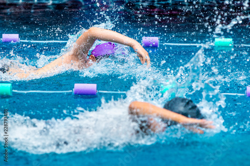 Young boy swimmers racing in freestyle