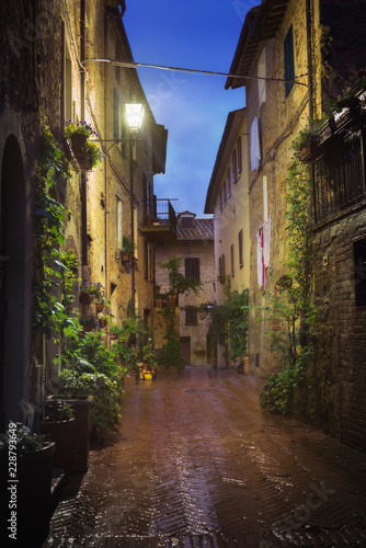Fototapeta Naklejka Na Ścianę i Meble -  Old European city Pienza street at rainy night, Tuscany, Italy