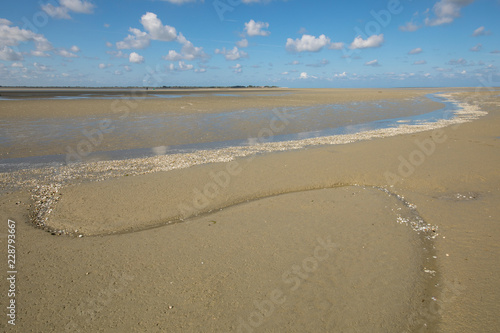 Litlle river flowing on the beach into sea, Somme Bay, Picardy, France.