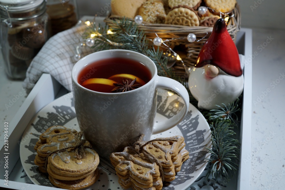 Decorative cookies in the shape of a Christmas tree and snowman and mulled wine with spices. 
