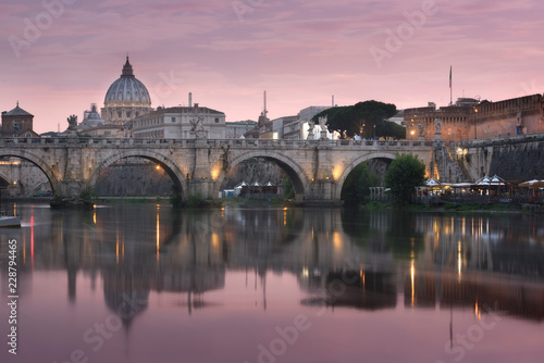 Vatican City, Rome, Italy, Beautiful Vibrant Night image Panorama of St. Peter's Basilica, Ponte St. Angelo and Tiber River at Dusk in Summer. Reflection of The Papal Basilica of St. Peter © Konstantin Maslak
