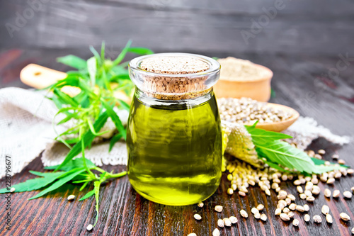 Oil hemp in jar with flour and grain on board