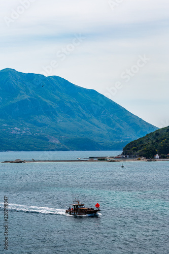 Fishing moments, beautiful springtime blue morning near Budva in Montenegro, vintage boat and the crystal waters of Adriatic Sea. Vertical landscape