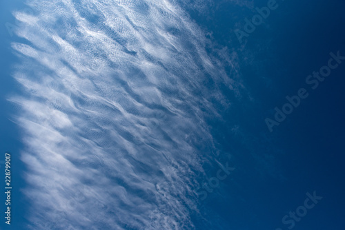 Shapes on blue sky with clouds.