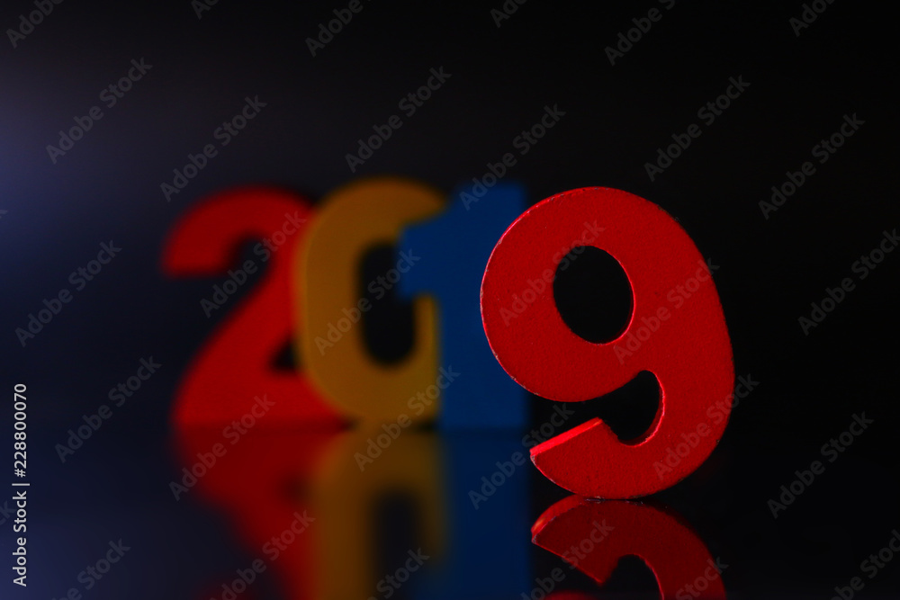 2019. Wooden color numbers 2019 with reflection on black background.