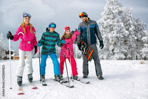 family with ski and snowboard on ski holiday in mountains