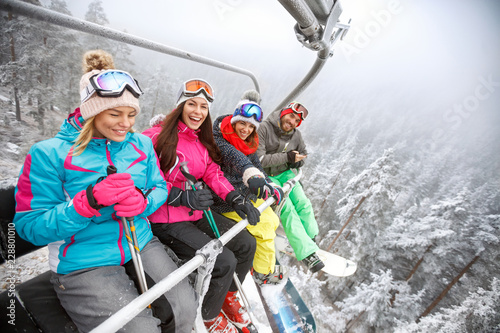 Skiers in ski lift lifting on ski terrain