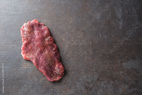 Obraz na plátně Portion of raw beef flank steak on butcher board