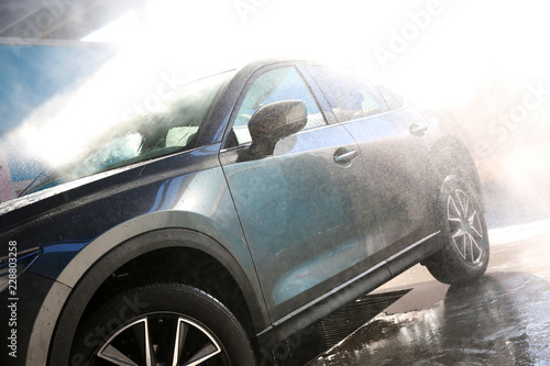Clean wet automobile at professional car wash