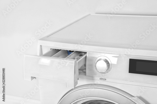 Washing machine with open detergent drawer on white background, closeup. Laundry day