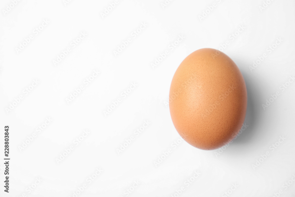 Raw brown chicken egg on white background, top view Raw brown chicken egg on white background, top view