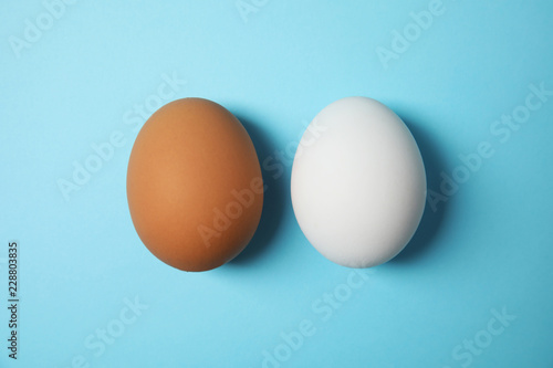 Raw chicken eggs on color background, top view