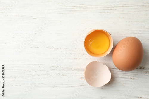 Raw chicken eggs on wooden background, top view. Space for text