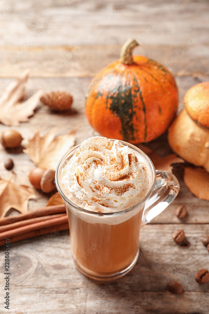 Glass cup with tasty pumpkin spice latte on wooden table Glass cup with tasty pumpkin spice latte on wooden table