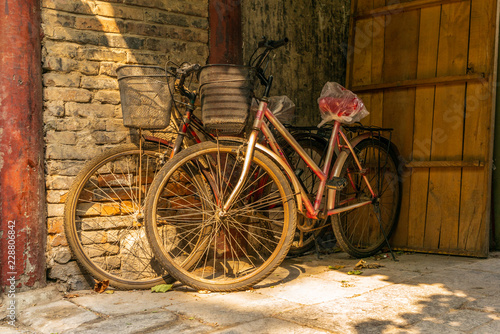 Old bikes in an empty narrow alley in a traditional Beijing Hutong in China - 1