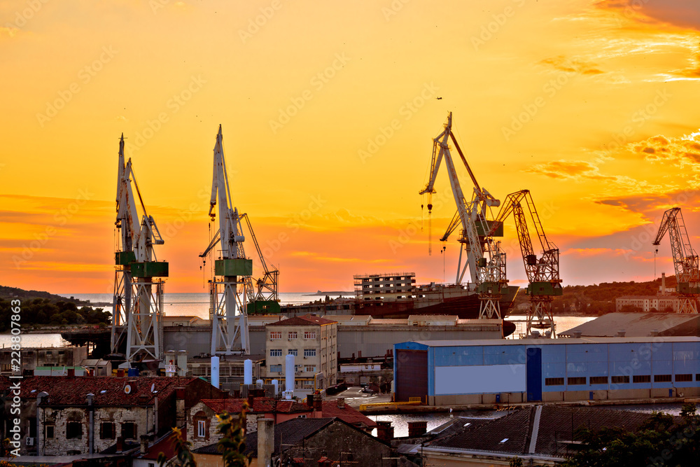 Town of Pula shipyard cranes sunset view Town of Pula shipyard cranes sunset view