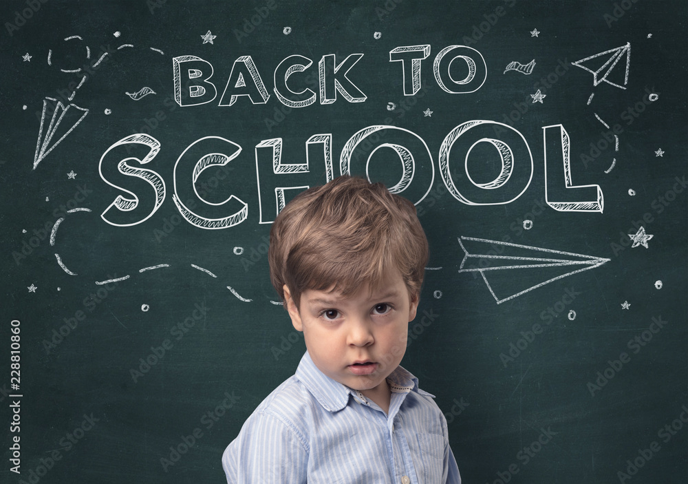 Adorable little boy with blackboard and back to school concept