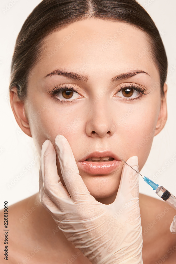 lip augmentation injection. Young woman. Doctor hand. Medical process
