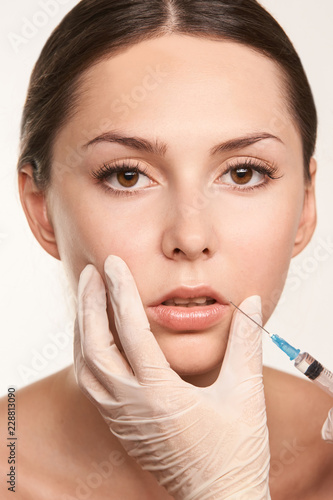 lip augmentation injection. Young woman. Doctor hand. Medical process