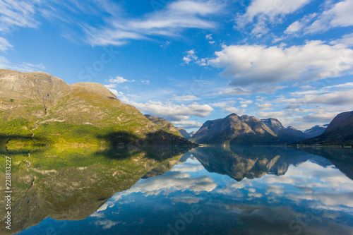 view on Geiranger fjord with reflections, blue sky, clouds