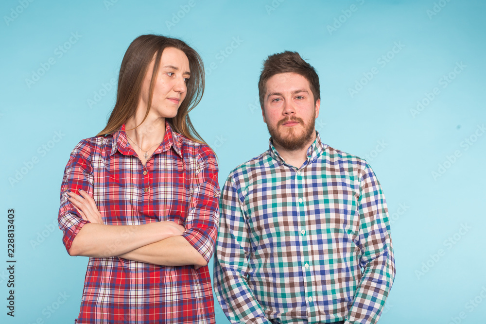 Cute funny couple in checkered shirts laughing on blue background Cute funny couple in checkered shirts laughing on blue background