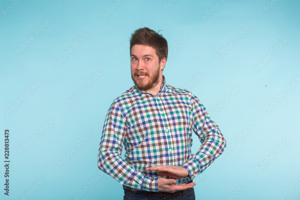 Close-up portrait of strange bearded handsome man on blue background Close-up portrait of strange bearded handsome man on blue background