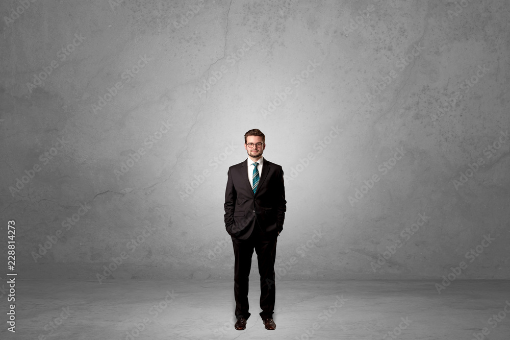 Alone handsome businessman standing in a dark empty room Alone handsome businessman standing in a dark empty room