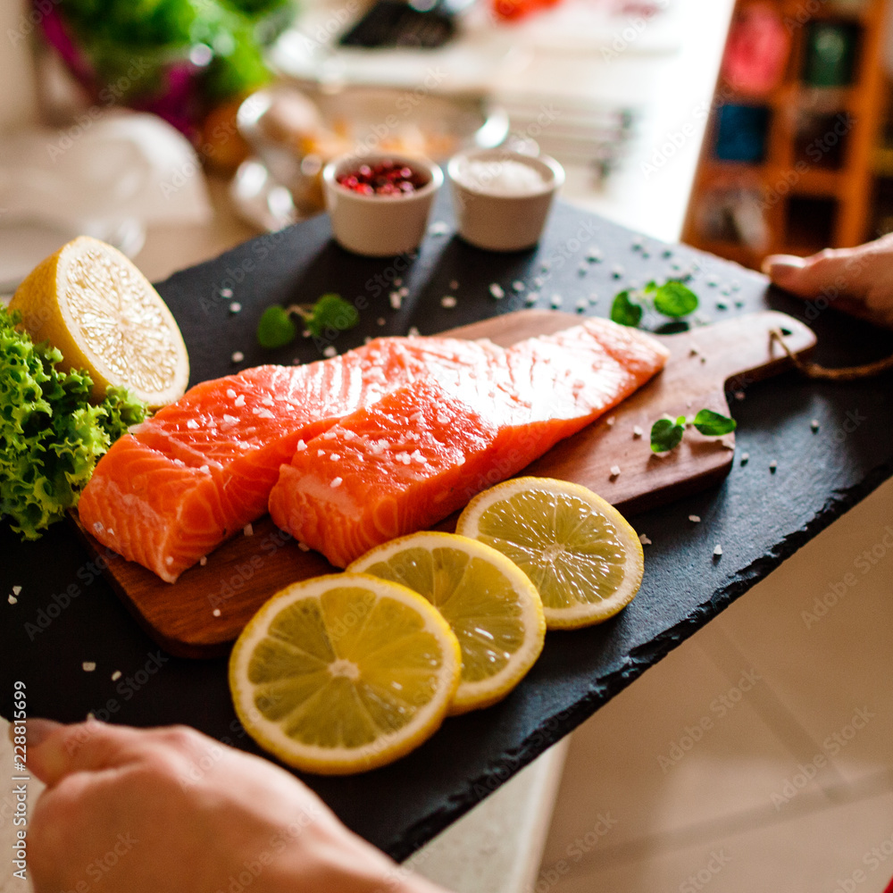 Fresh raw salmon fish served on black stone on wooden table Fresh raw salmon fish served on black stone on wooden table