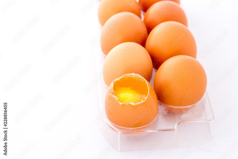 Chicken eggs one broken in a tray isolated against a white background image with copy space in landscape format Chicken eggs one broken in a tray isolated against a white background image with copy space in landscape format