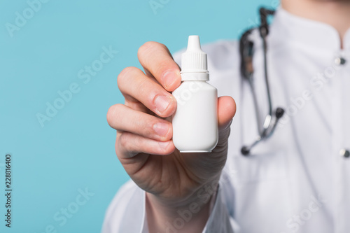 Medical drops in doctor's hand on blue background