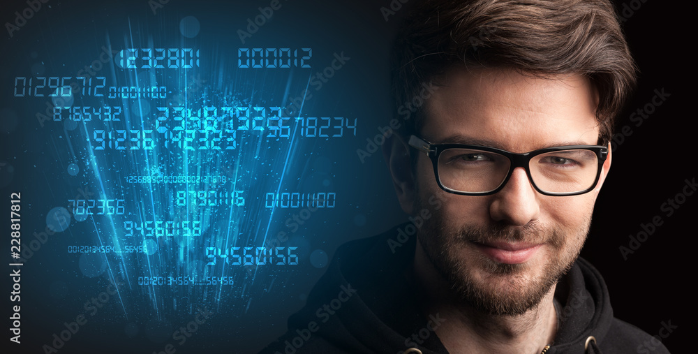 Portrait of a young businessman with blue numbers next to him on a dark background Portrait of a young businessman with blue numbers next to him on a dark background