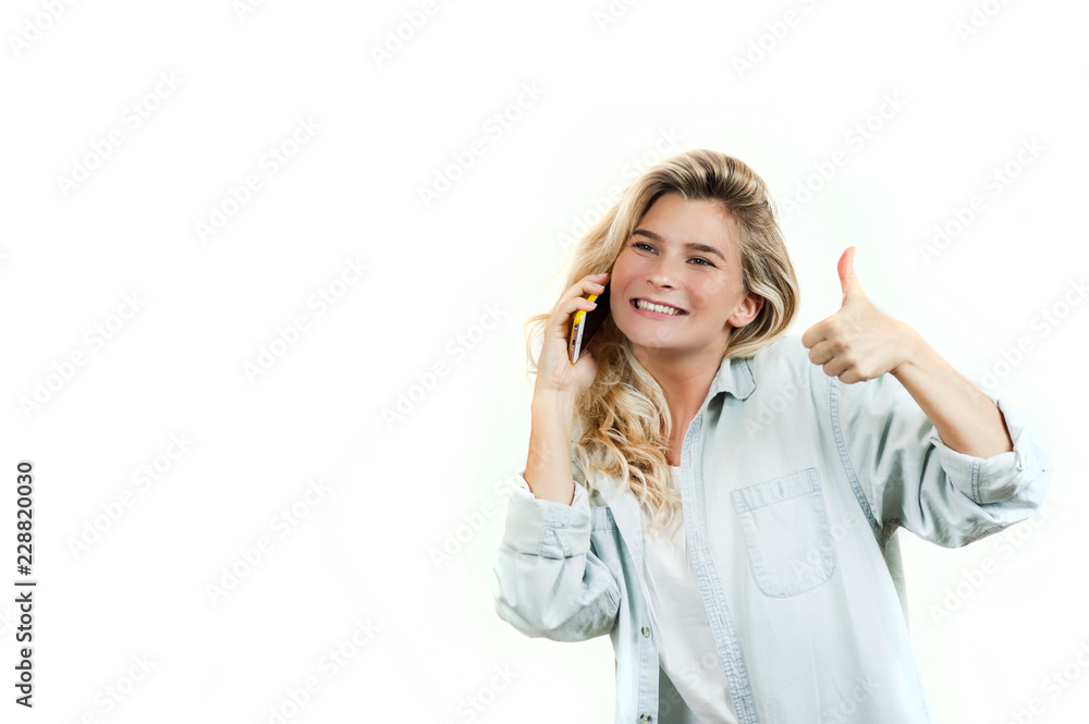 very beautiful young girl talking on the phone while standing on a white isolated background. very beautiful young girl talking on the phone while standing on a white isolated background.