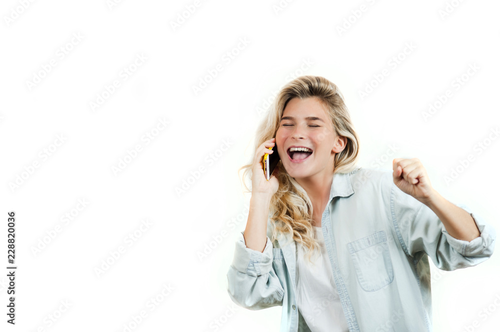 very beautiful young girl talking on the phone while standing on a white isolated background.
