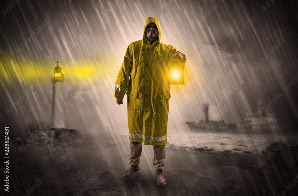Man at the coast coming in raincoat with glowing lantern concept
Man at the coast coming in raincoat with glowing lantern concept