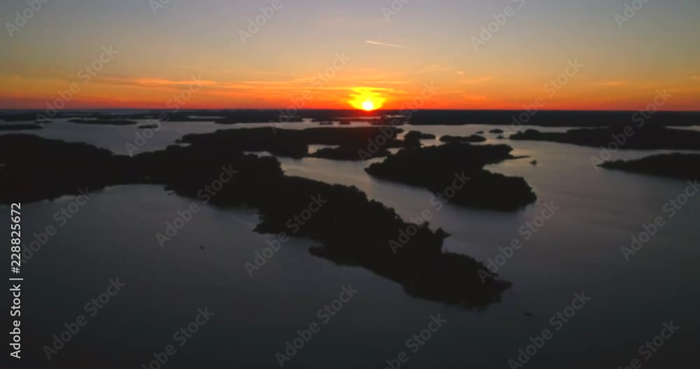 Finnish archipelago sunset, C4K aerial sideway shot, above the saaristo, of the sun reflecting between islands, on the gulf of Finland, on a summer evening, in Sando, Hanko, Uusimaa, Suomi Finnish archipelago sunset, C4K aerial sideway shot, above the saaristo, of the sun reflecting between islands, on the gulf of Finland, on a summer evening, in Sando, Hanko, Uusimaa, Suomi