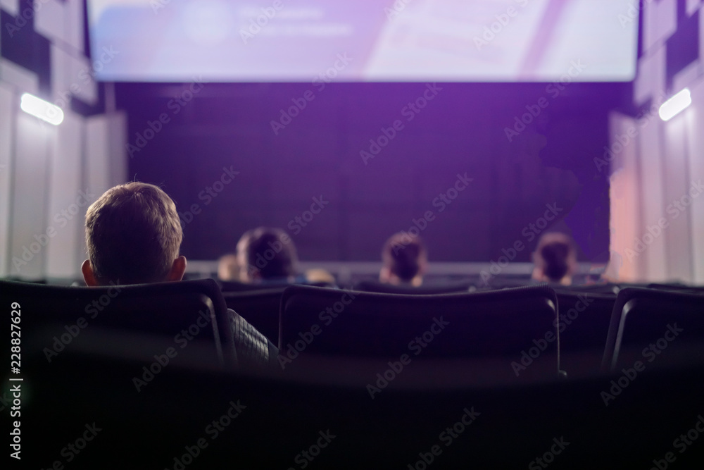 back view of people sit in cinema hall f