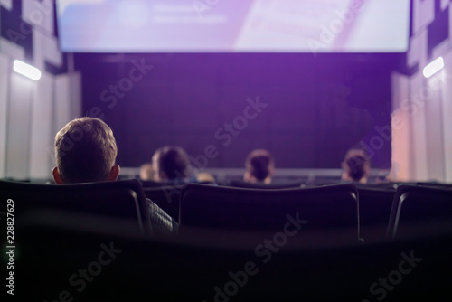 back view of people sit in cinema hall f