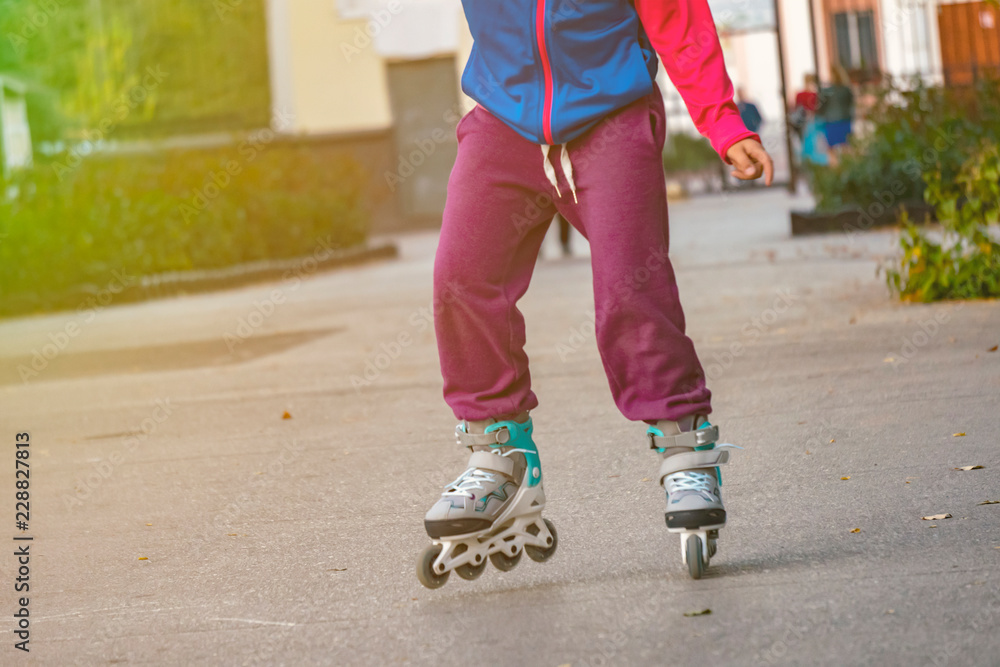 little kid riding the roller skates in the street f