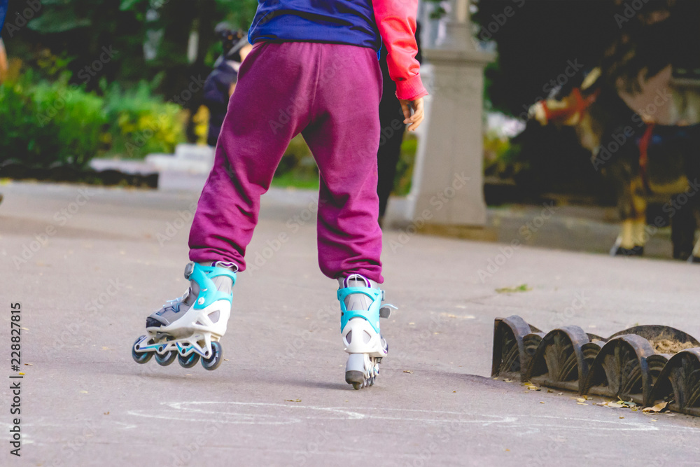 little kid riding the roller skates in the street f